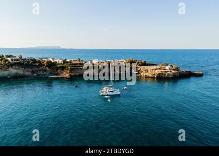 Drone vue de Catamaran ancré dans la mer bleue avec des gens nageant. Arrière-plan de voyage. Vacances en croisière. Banque D'Images