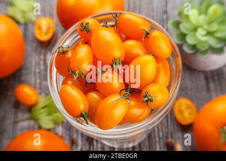 tomate cerise orange prune sur fond de bois Banque D'Images