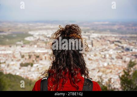 Vue arrière d'une jeune femme contemplant le paysage depuis le sommet d'une colline Banque D'Images