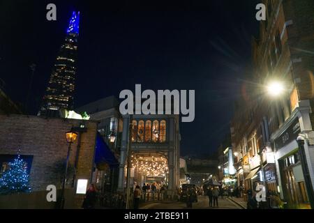 UK Weather, 6 décembre 2023, Londres : les tours Shard au-dessus des lumières du Borough Market au crépuscule un jour d'hiver. La pointe du Shard a un affichage lumineux changeant avec des couleurs sur le thème de Noël qui se démarquent dans le ciel nocturne. Crédit : Anna Watson/Alamy Live News Banque D'Images