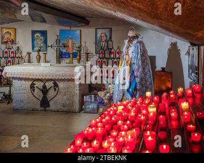 Saintes Maries de la Mer, France - 3 octobre 2023 : des bougies votives brûlent devant la statue de Sainte Sarah, la sainte patronne des gipsies, dans le cri Banque D'Images