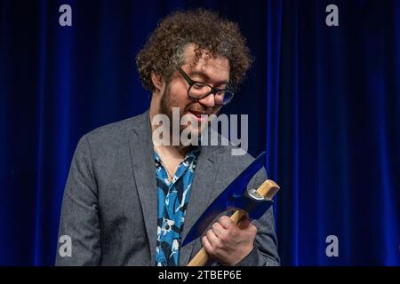 Passau, Allemagne. 07 décembre 2023. David Stockenreitner, artiste de cabaret autrichien, tient le ScharfrichterBeil. Le prix cabaret a été décerné pour la 40e fois à Passau. Il s’adresse aux artistes émergents et est l’un des prix de cabaret les plus prestigieux du monde germanophone. Crédit : Armin Weigel/dpa/Alamy Live News Banque D'Images