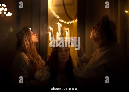 Londres, Royaume-Uni. 6 décembre 2023. Célébrations de Sankta Lucia à l’église St John’s Wood. Astrid Hjerting du London Nordic Choir jouant le rôle de St Lucy, voit sa couronne de bougies éteinte après un concert réussi. La célébration de Sankta Lucia est basée sur la bravoure et le martyre d'une jeune fille sicilienne Sainte Lucie (Lucie de Syracuse 283-304). Le septième concert annuel Sankta Lucia and Christmas carol du London Nordic Choir, un chœur de chambre indépendant, connu pour ses performances vibrantes du répertoire cappella avec une passion pour la musique chorale scandinave. Crédit : Guy Corbishley/Alamy Live Banque D'Images