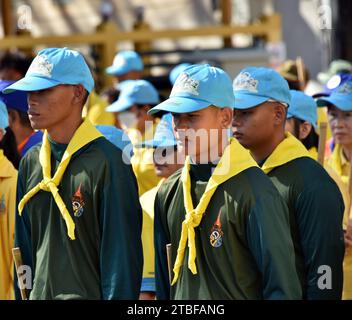 De jeunes représentants de l'armée royale thaïlandaise aident les autres lors d'une journée nationale de nettoyage à Nakhon Phanom, en Thaïlande, en Asie du Sud-est. Le 5 décembre est une fête nationale car il commémore l'anniversaire du défunt roi Bhumibol Adulyadej, Rama 9. Cet événement commence par des participants en uniforme qui défilent pour des photos et de courts discours, suivis par tous ceux qui utilisent des brosses brindilles et des camions-citernes pour nettoyer les rues. Cette journée est connue sous le nom de fête des pères en Thaïlande. Banque D'Images