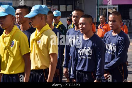 De jeunes représentants de l'armée royale thaïlandaise aident les autres lors d'une journée nationale de nettoyage à Nakhon Phanom, en Thaïlande, en Asie du Sud-est. Le 5 décembre est une fête nationale car il commémore l'anniversaire du défunt roi Bhumibol Adulyadej, Rama 9. Cet événement commence par des participants en uniforme qui défilent pour des photos et de courts discours, suivis par tous ceux qui utilisent des brosses brindilles et des camions-citernes pour nettoyer les rues. Cette journée est connue sous le nom de fête des pères en Thaïlande. Banque D'Images