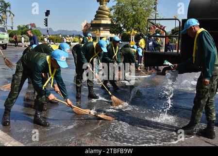 De jeunes représentants de l'armée royale thaïlandaise aident les autres lors d'une journée nationale de nettoyage à Nakhon Phanom, en Thaïlande, en Asie du Sud-est. Le 5 décembre est une fête nationale car il commémore l'anniversaire du défunt roi Bhumibol Adulyadej, Rama 9. Cet événement commence par des participants en uniforme qui défilent pour des photos et de courts discours, suivis par tous ceux qui utilisent des brosses brindilles et des camions-citernes pour nettoyer les rues. Cette journée est connue sous le nom de fête des pères en Thaïlande. Banque D'Images