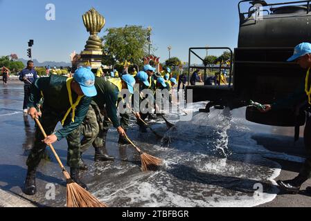 De jeunes représentants de l'armée royale thaïlandaise aident les autres lors d'une journée nationale de nettoyage à Nakhon Phanom, en Thaïlande, en Asie du Sud-est. Le 5 décembre est une fête nationale car il commémore l'anniversaire du défunt roi Bhumibol Adulyadej, Rama 9. Cet événement commence par des participants en uniforme qui défilent pour des photos et de courts discours, suivis par tous ceux qui utilisent des brosses brindilles et des camions-citernes pour nettoyer les rues. Cette journée est connue sous le nom de fête des pères en Thaïlande. Banque D'Images