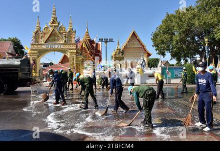 De jeunes représentants de l'armée royale thaïlandaise aident les autres lors d'une journée nationale de nettoyage à Nakhon Phanom, en Thaïlande, en Asie du Sud-est. Le 5 décembre est une fête nationale car il commémore l'anniversaire du défunt roi Bhumibol Adulyadej, Rama 9. Cet événement commence par des participants en uniforme qui défilent pour des photos et de courts discours, suivis par tous ceux qui utilisent des brosses brindilles et des camions-citernes pour nettoyer les rues. Cette journée est connue sous le nom de fête des pères en Thaïlande. Banque D'Images