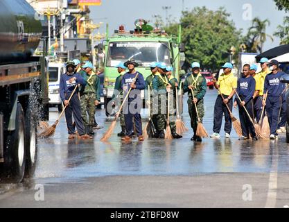 De jeunes représentants de l'armée royale thaïlandaise aident les autres lors d'une journée nationale de nettoyage à Nakhon Phanom, en Thaïlande, en Asie du Sud-est. Le 5 décembre est une fête nationale car il commémore l'anniversaire du défunt roi Bhumibol Adulyadej, Rama 9. Cet événement commence par des participants en uniforme qui défilent pour des photos et de courts discours, suivis par tous ceux qui utilisent des brosses brindilles et des camions-citernes pour nettoyer les rues. Cette journée est connue sous le nom de fête des pères en Thaïlande. Banque D'Images