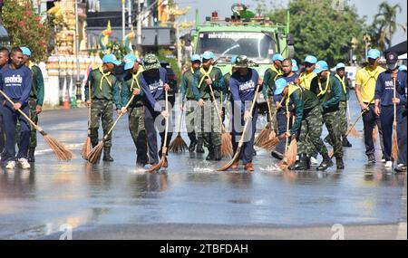 De jeunes représentants de l'armée royale thaïlandaise aident les autres lors d'une journée nationale de nettoyage à Nakhon Phanom, en Thaïlande, en Asie du Sud-est. Le 5 décembre est une fête nationale car il commémore l'anniversaire du défunt roi Bhumibol Adulyadej, Rama 9. Cet événement commence par des participants en uniforme qui défilent pour des photos et de courts discours, suivis par tous ceux qui utilisent des brosses brindilles et des camions-citernes pour nettoyer les rues. Cette journée est connue sous le nom de fête des pères en Thaïlande. Banque D'Images