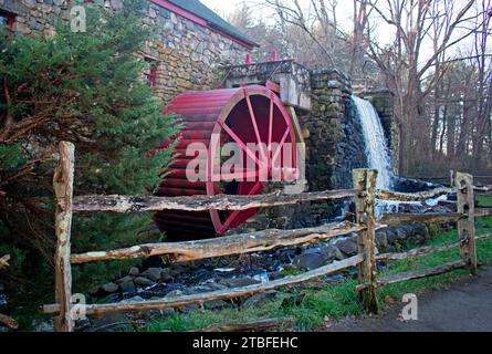 Moulin à grist historique arborant une roue en bois rouge, à Sudbury, Massachusetts, qui est toujours en activité, produisant de la farine de maïs et de la farine de blé - Banque D'Images