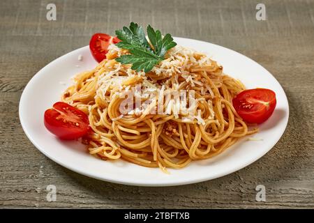 assiette de spaghetti avec sauce bolognaise et tomates sur table de cuisine en bois Banque D'Images