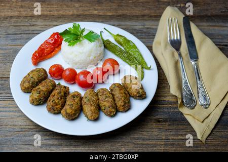 Boulettes de viande chypriotes, servies avec poivrons frits, riz pilaf et tomates. Banque D'Images