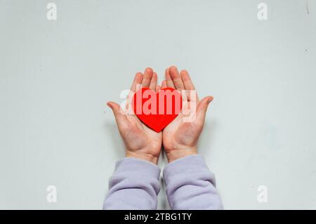 Un coeur rouge dans la main d'un enfant Banque D'Images