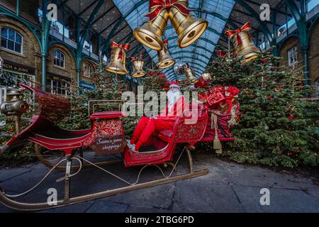 Père Noël assis dans le traîneau « Santa's Gone shopping » à Covent Garden pendant les fêtes de fin d'année. Banque D'Images