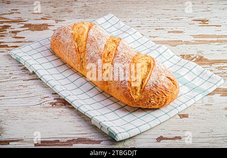 Une miche de pain de grains entiers fraîchement cuite reposant sur un torchon de cuisine Banque D'Images