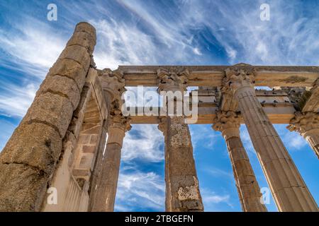 Vue de dessous des colonnes de marbre avec des chapiteaux grecs du temple romain de Diane avec des colombes perchées sur le frontispice. Merida, Espagne. Banque D'Images