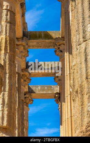 Vue de dessous des colonnes de marbre et de granit ramées du temple romain de Diane avec des colombes perchées sur ses poutres. Merida, Espagne. Drapeau vertical. Banque D'Images