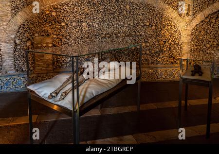 Momies d'un cadavre humain et d'un enfant dans une urne funéraire dans la chapelle des os située dans la ville d'Évora au Portugal. Banque D'Images