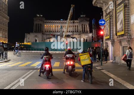 Rome, RM, Italie. 6 décembre 2023. Scooters et coureurs sont arrêtés aux feux de circulation sur la Piazza Venezia à Rome (crédit image : © Matteo Nardone/Pacific Press via ZUMA Press Wire) POUR USAGE ÉDITORIAL SEULEMENT! Non destiné à UN USAGE commercial ! Banque D'Images