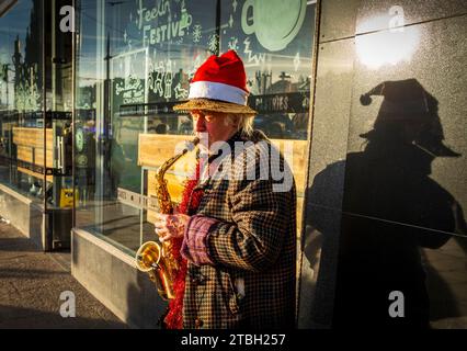 Busker festif à Princes Street à l'occasion de Noël 2023 d'Édimbourg – dans les jardins de Princes Street, Édimbourg Banque D'Images