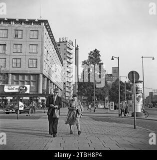 Une vue de la rue de Rotterdam en 1955 – elle a été photographiée en regardant vers le sud avec des gens marchant sur Coolsingel à l'intersection avec Beursplein. Beursplein est maintenant piétonne avec un centre commercial et une station de métro sous le niveau du sol. Un grand magasin de vêtements C&A est au coin de la rue (aujourd'hui grandement modernisé) - une photographie vintage des années 1950. Banque D'Images