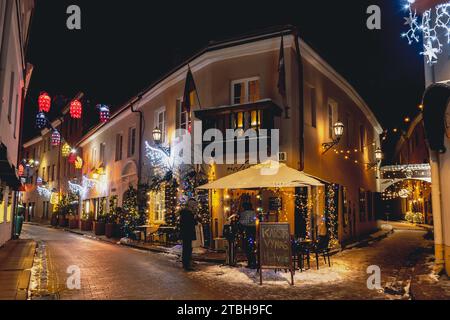 Belle vue sur la rue avec décorations de Noël confortables, couronne, guirlandes et lumières dans la vieille ville de Vilnius, capitale de la Lituanie, Europe, la nuit Banque D'Images