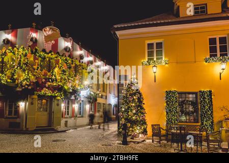 Belles décorations de Noël confortables, couronne, guirlandes et lumières dans la vieille ville de Vilnius, capitale de la Lituanie, Europe, la nuit avec des lampadaires Banque D'Images