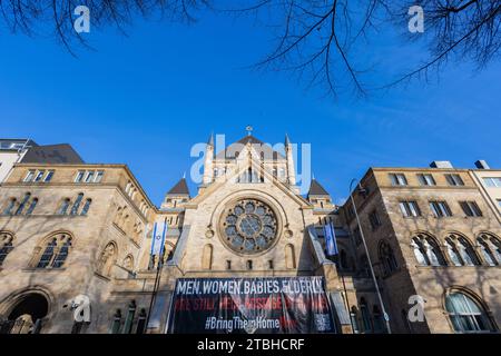 Cologne, Allemagne. 07 décembre 2023. Une bannière avec l'inscription 'Men. Femmes. Bébés. Personnes âgées. Sont toujours pris en otage par les stands du Hamas devant un candélabre Hanukkah devant la synagogue. Hanukkah, qui commence aujourd'hui, est une fête juive annuelle qui dure huit jours. Crédit : Rolf Vennenbernd/dpa/Alamy Live News Banque D'Images