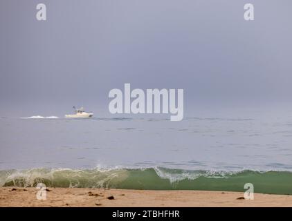 petit bateau à moteur blanc au large de la plage de point de vol Banque D'Images