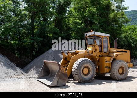 Puissant chargeur sur pneus ou bulldozer travaillant sur un chantier de construction. Banque D'Images