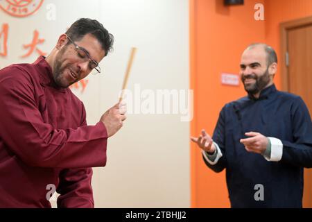 (231207) -- TIANJIN, 7 déc. 2023 (Xinhua) -- Raydis Franco (L) et Santiago Arag¨®n répètent une représentation de diaphonie dans la salle de classe du Collège des langues étrangères de l'Université Nankai, Tianjin du nord de la Chine, le 6 décembre 2023. Raydis Franco du Venezuela et Santiago Arag¨®n de l'Espagne sont tous deux professeurs d'espagnol travaillant au Collège des langues étrangères de l'Université Nankai, à Tianjin, dans le nord de la Chine. Attirés par la culture chinoise, ils ont commencé à apprendre et à jouer le cross-talk chinois en espagnol. Franco est le dougen, un orateur principal qui livre des lignes de frappe et des blagues, tandis que Arag¨®n ta Banque D'Images