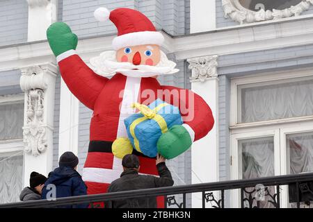 KIEV, UKRAINE - le 6 DÉCEMBRE 2023 - des travailleurs installent un Père Noël gonflable devant un bâtiment dans le centre-ville le jour de la Saint-Nicolas avant la CHRI Banque D'Images