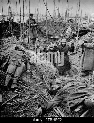 Les soldats russes font prisonnier les troupes de la Wermacht près de Staraya lors de l'invasion allemande de la Russie en avril 1942. Un soulagement promis qui est venu trop tard pour les envahisseurs encerclés et maintenant capturés ont combattu dur, comme on peut le voir par les corps de leurs collègues couchés près des tranchées. Banque D'Images