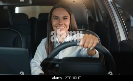 Femme caucasienne fille femme conducteur assise dans la voiture de location à l'intérieur dans l'automobile souriant heureux à la conduite de caméra profiter de l'achat de nouveau véhicule de transport automatique Banque D'Images