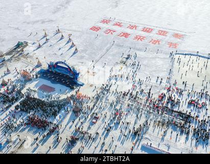 (231207) -- HARBIN, 7 déc. 2023 (Xinhua) -- cette photo aérienne montre un festival de collecte de glace sur la rivière Songhua à Harbin, capitale de la province du Heilongjiang dans le nord-est de la Chine, le 7 décembre 2023. Les glaçons recueillis dans la rivière Songhua gelée seront utilisés dans la décoration de la ville. (Xinhua/Xie Jianfei) Banque D'Images