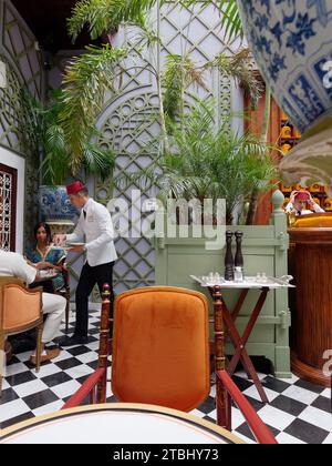 Café Bacha à l'intérieur du palais de Dar el Bacha. Membre du personnel avec Fez Hat sert les clients. Marrakech alias Marrakech, Maroc, 07 décembre 2023 Banque D'Images