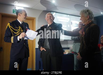 Le colonel français Xavier Ravel (à gauche) surprend David Morgan, 100 ans, vétéran de la Seconde Guerre mondiale, alors qu'il lui présente la Légion d'honneur pour sa participation aux opérations du jour J, avec Arlette Gondree à l'honneur, lors de la fête de Noël taxi Charity for Military Veterans au Millwall football Club de Londres. Date de la photo : jeudi 7 décembre 2023. Banque D'Images