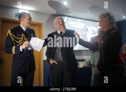 Le colonel français Xavier Ravel (à gauche) surprend David Morgan, 100 ans, vétéran de la Seconde Guerre mondiale, alors qu'il lui présente la Légion d'honneur pour sa participation aux opérations du jour J, avec Arlette Gondree à l'honneur, lors de la fête de Noël taxi Charity for Military Veterans au Millwall football Club de Londres. Date de la photo : jeudi 7 décembre 2023. Banque D'Images