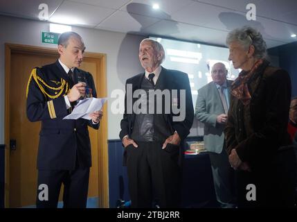 Le colonel français Xavier Ravel (à gauche) surprend David Morgan, 100 ans, vétéran de la Seconde Guerre mondiale, alors qu'il lui présente la Légion d'honneur pour sa participation aux opérations du jour J, avec Arlette Gondree à l'honneur, lors de la fête de Noël taxi Charity for Military Veterans au Millwall football Club de Londres. Date de la photo : jeudi 7 décembre 2023. Banque D'Images