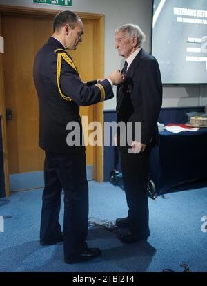 Le colonel français Xavier Ravel (à gauche) surprend David Morgan, 100 ans, vétéran de la Seconde Guerre mondiale, alors qu'il lui présente la Légion d'honneur pour sa participation aux opérations du jour J, lors de la fête de Noël taxi Charity for Military Veterans au Millwall football Club de Londres. Date de la photo : jeudi 7 décembre 2023. Banque D'Images