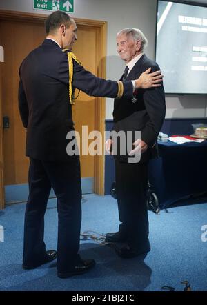 Le colonel français Xavier Ravel (à gauche) surprend David Morgan, 100 ans, vétéran de la Seconde Guerre mondiale, alors qu'il lui présente la Légion d'honneur pour sa participation aux opérations du jour J, lors de la fête de Noël taxi Charity for Military Veterans au Millwall football Club de Londres. Date de la photo : jeudi 7 décembre 2023. Banque D'Images