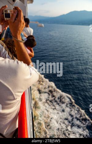 Passagers sur le ferry Nice Bastia au départ de Nice photographiant le paysage, France. Banque D'Images