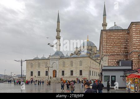 Istanbul, Turquie - 18 octobre 2023 : foule de gens devant la nouvelle mosquée Yeni Cami lors du jour d'automne pluvieux. Banque D'Images