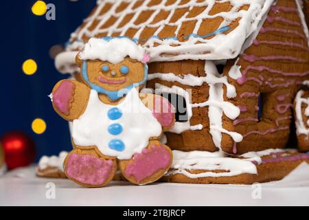 Le pain d'épice de Noël en forme d'homme est décoré avec un glaçage au sucre coloré et une maison à biscuits. Banque D'Images