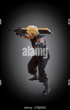 NEC, BIRMINGHAM, ROYAUME-UNI - 3 DÉCEMBRE 2023. Cosplayer masculin habillé comme le personnage de final Fantasy Cloud Strife lors d'un événement comique britannique avec perruque blonde et Banque D'Images