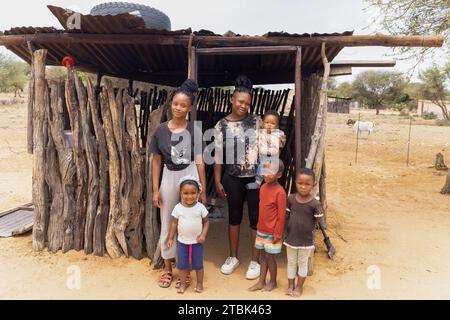 village, famille africaine situé en face de la cabane de cuisine en plein air dans la cour, mère avec des enfants Banque D'Images