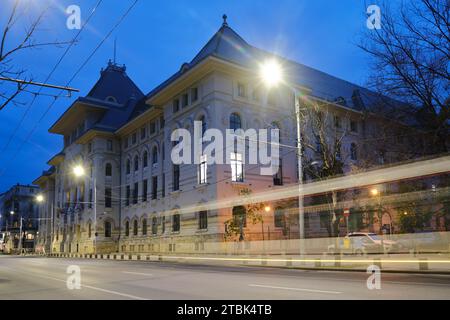 Bâtiment de la mairie de Bucarest extérieur avec piste de voiture au crépuscule. Point de repère de l'administration dans la capitale de la Roumanie. Banque D'Images