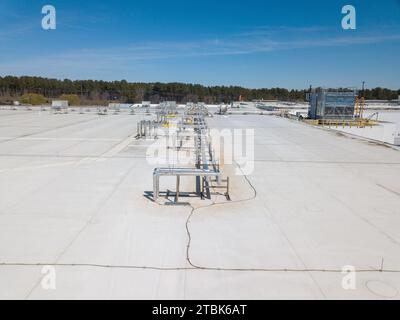 Images drone du toit d'un entrepôt de distribution alimentaire et d'un quartier en construction Banque D'Images