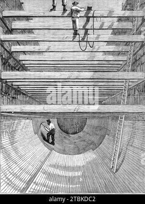 London main drainage : Construction de l'inversion pour l'égout de haut niveau sud, 1861. 'L'égout de l'émissaire nord est d'environ cinq miles de long.... la manière remarquable dont le remblai ou le lit est formé sur lequel les tunnels doivent être construits sera mieux comprise par référence à notre illustration. L'ensemble du sol supérieur est d'abord excavé, puis un remblai solide de béton est formé. Dans certains endroits, ce remblai mesure jusqu'à vingt pieds de profondeur et cent pieds de largeur. Il est formé en réalisant un étage sur lequel sont posées plusieurs lignes de rails. Le béton est fait o Banque D'Images